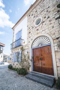 een bakstenen gebouw met een houten deur en trap bij Kurabiye Hotel in Alacati