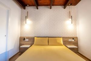 1 dormitorio con cama amarilla y pared en Avenida 12, en Alghero