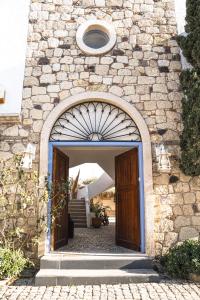 einen Eingang zu einem Steingebäude mit Torbogen in der Unterkunft Kurabiye Hotel in Alacati