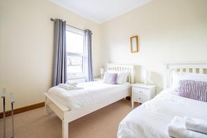 1 Schlafzimmer mit 2 Betten und einem Fenster in der Unterkunft 7 Buckingham Street in York