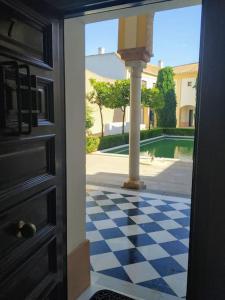 a door with a checkered floor in front of a courtyard at Duplex near MEZQUITA of Córdoba & Free Private Parking in Córdoba