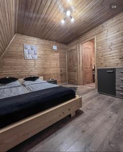 a bedroom with a bed and a wooden wall at Valdo Cabin in Sadu