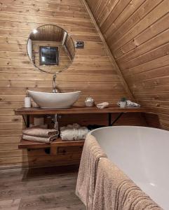 a bathroom with a tub and a sink and a mirror at Valdo Cabin in Sadu