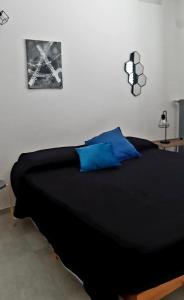 una camera da letto con letto nero e cuscini blu di ANDIRIVIENI☆LECCE ☆CASA VACANZE LECCE a Lecce