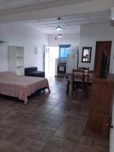 uma sala de estar com uma cama e uma sala de jantar em Departamentos Rosales em Valeria del Mar
