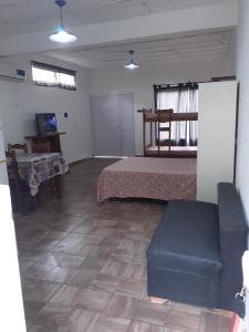 um quarto com uma cama e um sofá num quarto em Departamentos Rosales em Valeria del Mar