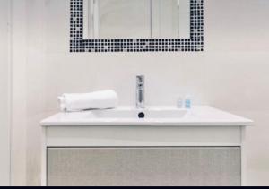 a bathroom with a white sink and a mirror at Lovely studio at the city heart! in Málaga +3 photos
