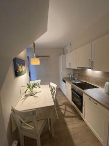 - une cuisine avec une table, une table et des chaises dans l'établissement Haus-Seeschwalbe-Wohnung-2, à Nieblum