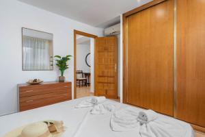 1 dormitorio con 1 cama y puerta de madera en Villa Caleta - PlusHolidays, en Calpe
