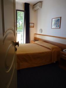 a hotel room with two beds and a window at Hotel Gambrinus in Lido di Jesolo