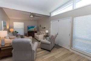 a living room with a couch and chairs and a tv at Cathy and Jim's Florida Beach House in Fort Walton Beach