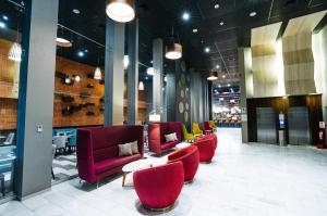 a lobby with a row of red chairs and tables at BTH Rebel Tacna in Tacna