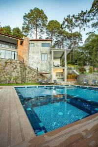 a large swimming pool in front of a house at Modern Apartment with Jacuzzi and Pool in Valle de Bravo