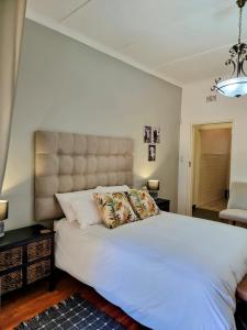 sypialnia z dużym białym łóżkiem z poduszkami w obiekcie Sonskyn Hof Guest House / Gastehuis w mieście Jan Kempdorp