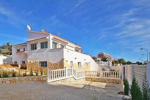 een wit huis met een hek ervoor bij Villa Calalga - PlusHolidays in Calpe