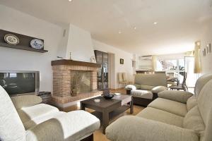 a living room with two couches and a fireplace at Villa Calalga - PlusHolidays in Calpe