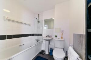 a white bathroom with a toilet and a sink at Luxe 1 bed flat 5 mins to Stratford - Free Parking in London