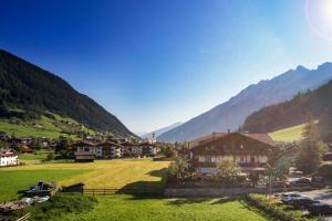ein Dorf in einem Tal mit Bergen im Hintergrund in der Unterkunft Hotel Brunnenhof in Neustift im Stubaital