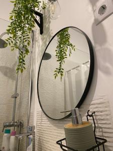 a bathroom with a round mirror on a wall at Casa do Mocho II in Lisbon