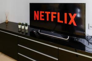a television on a dresser with a netflix sign on it at Luxe 1 bed flat 5 mins to Stratford - Free Parking in London