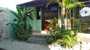 a house with a wooden door and some plants at Chalé Claudio Rambo in Ilhabela