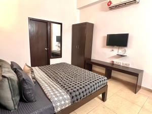 a bedroom with a bed and a desk with a television at Room with attach washroom on main road- Rajiv Chowk Gurgaon in Gurgaon