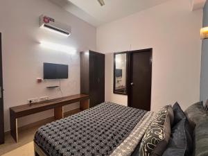 a bedroom with a bed and a desk and a television at Room with attach washroom on main road- Rajiv Chowk Gurgaon in Gurgaon