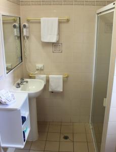 a bathroom with a sink and a shower at City Motor Inn in Toowoomba +3 photos