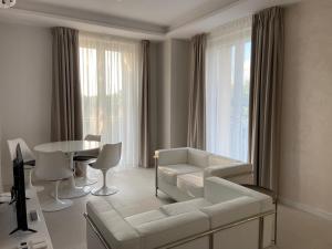 GT Apartments - New opening في فيبو فالينتيا مارينا: غرفة معيشة مع أريكة بيضاء وطاولة