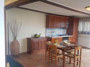 a kitchen with a wooden table and chairs and a table and a table at Soggiorno baciato dal sole in Forio d'Ischia