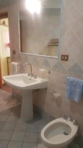 a bathroom with a sink and a toilet and a mirror at Soggiorno baciato dal sole in Forio d'Ischia