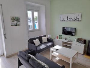 uma sala de estar com um sofá e uma mesa em Guest dAires em Coimbra