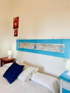 een slaapkamer met een bed met een blauw bord aan de muur bij "IL CASALE DEI GIRASOLI" Country House in Capalbio in Capalbio