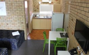 a kitchen with a table and chairs and a refrigerator at City Motor Inn in Toowoomba