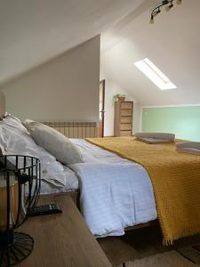 een slaapkamer met een groot bed met witte lakens bij Grandma’s Cottage in Săcele