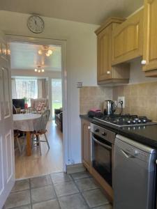 a kitchen with a stove and a dining room at Luxury Super King Bed in Stratford-upon-Avon