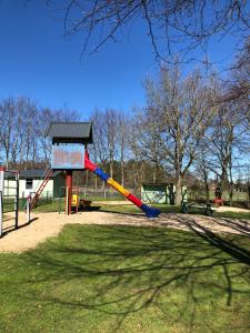 a playground with a slide in a park at Lütte Uttiet in Stelle-Wittenwurth
