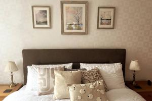 1 dormitorio con 1 cama con 3 cuadros en la pared en Luxury Super King Bed, en Stratford-upon-Avon