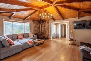 - un salon avec un canapé et des plafonds en bois dans l'établissement Cherry Cottage 15 min from Yosemite South Entrance, à Oakhurst