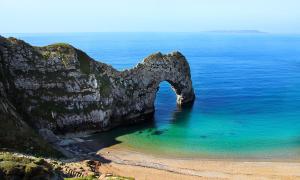 uma formação rochosa no oceano ao lado de uma praia em Bournemouth Luxury Hot Tub 1 Bed Garden Flat em Bournemouth