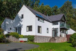 a white house with a stone wall at Hafod Rowen in Llangelynin