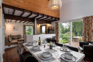 a dining room with a table and a living room at Hafod Rowen in Llangelynin