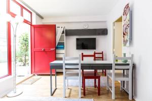 a dining room with a table and chairs and a red door at Paris Studio @Arc de Triomphe in Paris