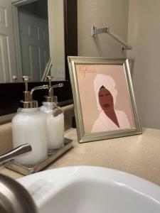 a picture of a woman on a bathroom counter next to a sink at Pink Tulum Houston 2min from Galleria in Houston