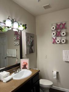 a bathroom with a sink and a toilet and a mirror at Pink Tulum Houston 2min from Galleria in Houston