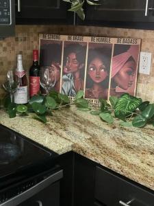a counter with bottles and glasses and posters on it at Pink Tulum Houston 2min from Galleria in Houston