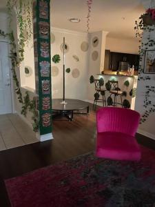 a living room with a pink chair and a table at Pink Tulum Houston 2min from Galleria in Houston