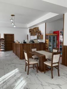 a dining room with a table and chairs and a kitchen at Hotel Dia Lin in Borşa