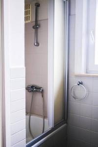 La salle de bains est pourvue d'une douche avec une porte en verre. dans l'établissement holiday vibes! penthouse-studio near beach, à Ostende