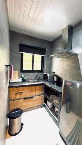 a small kitchen with a sink and a stove at Le Port Guest House in Baie Sainte Anne